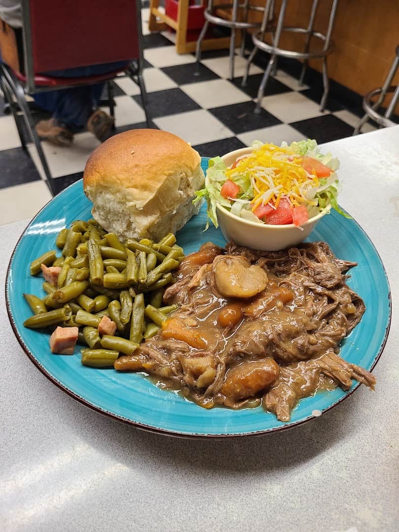 Southern comfort food plate with beef tips, green beans and a roll at Whistle Stop Cafe in Decatur, Texas
