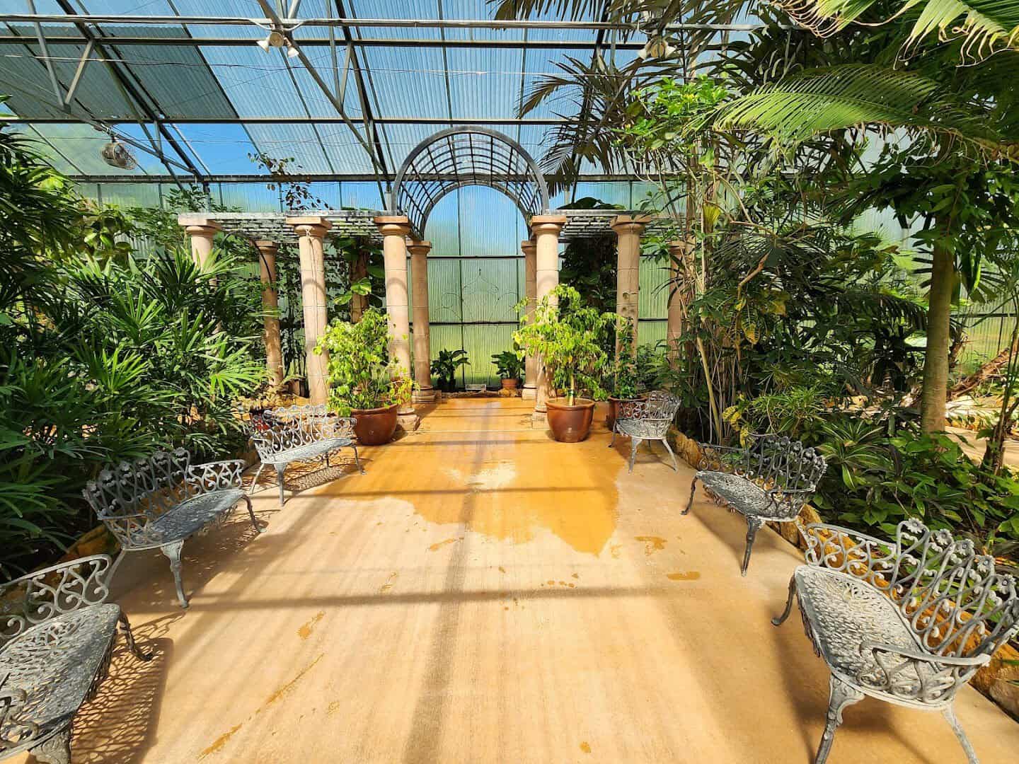 Glass conservatory interior with columns and benches at Beaumont Botanical Gardens