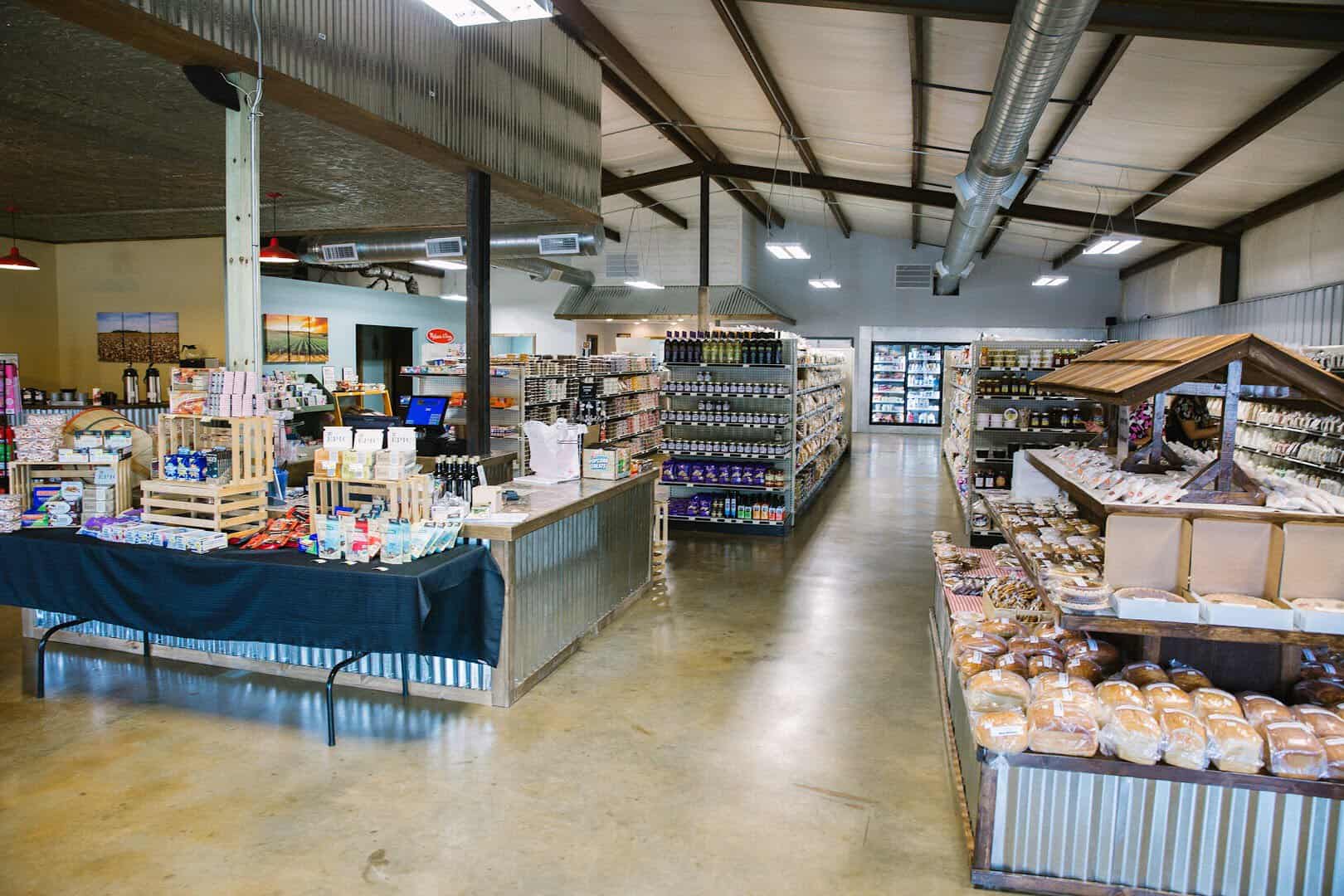 Wide view inside Olde Towne Country Store in Itasca Texas with the bakery table and shelves