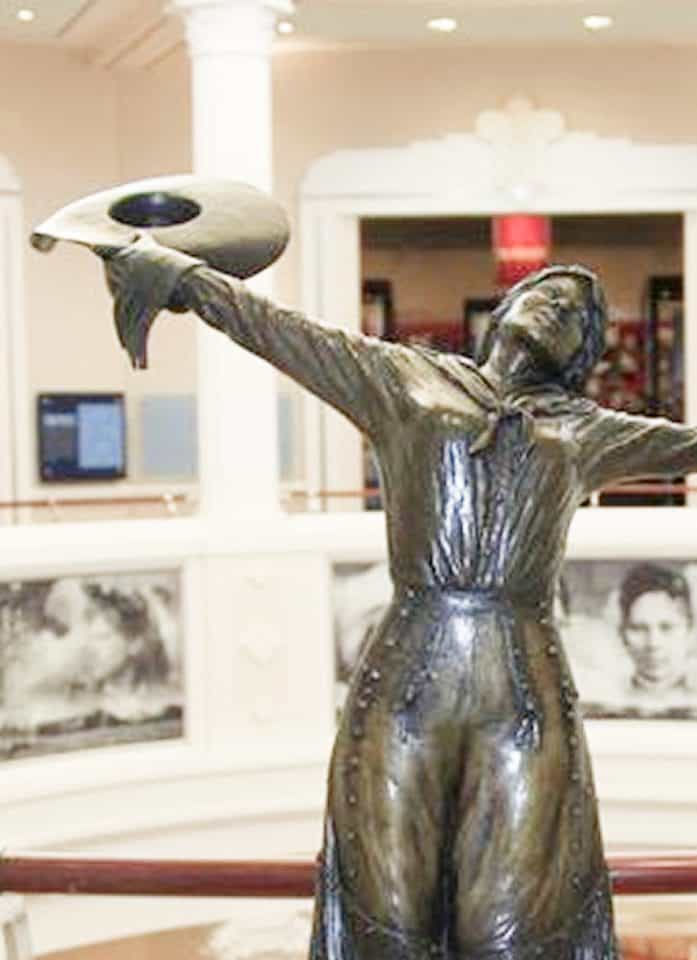 Bronze statue of a cowgirl raising her hat in the rotunda of the National Cowgirl Museum