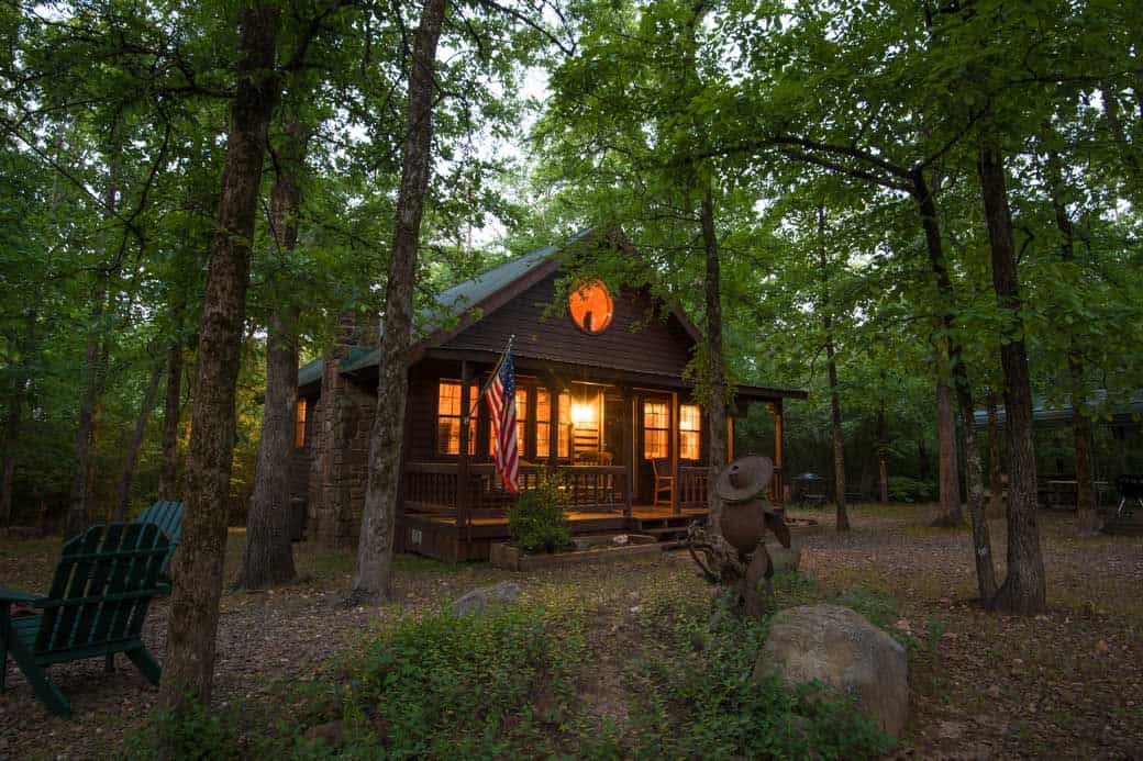 A cozy log cabin glowing at dusk in the pine woods near Beavers Bend, Broken Bow, Oklahoma