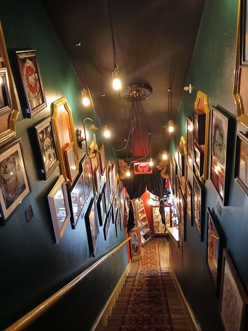 Lantern-lit corridor lined with framed art at Curia Arcanum in Austin, Texas
