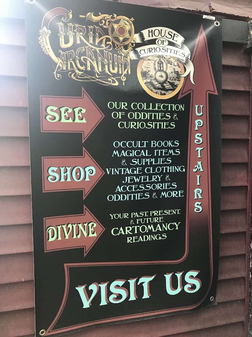 Curia Arcanum shop sign listing oddities, occult books and cartomancy readings in Austin, Texas