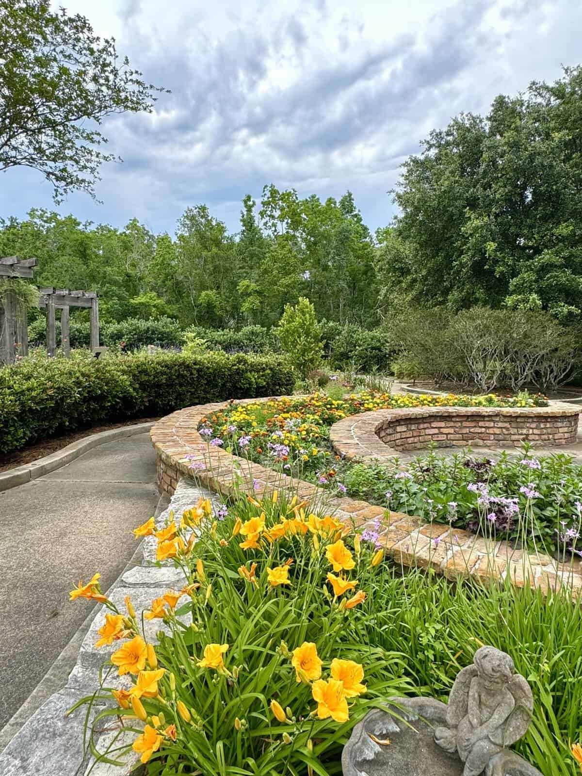 Colorful daylily and marigold beds along a brick path at Beaumont Botanical Gardens