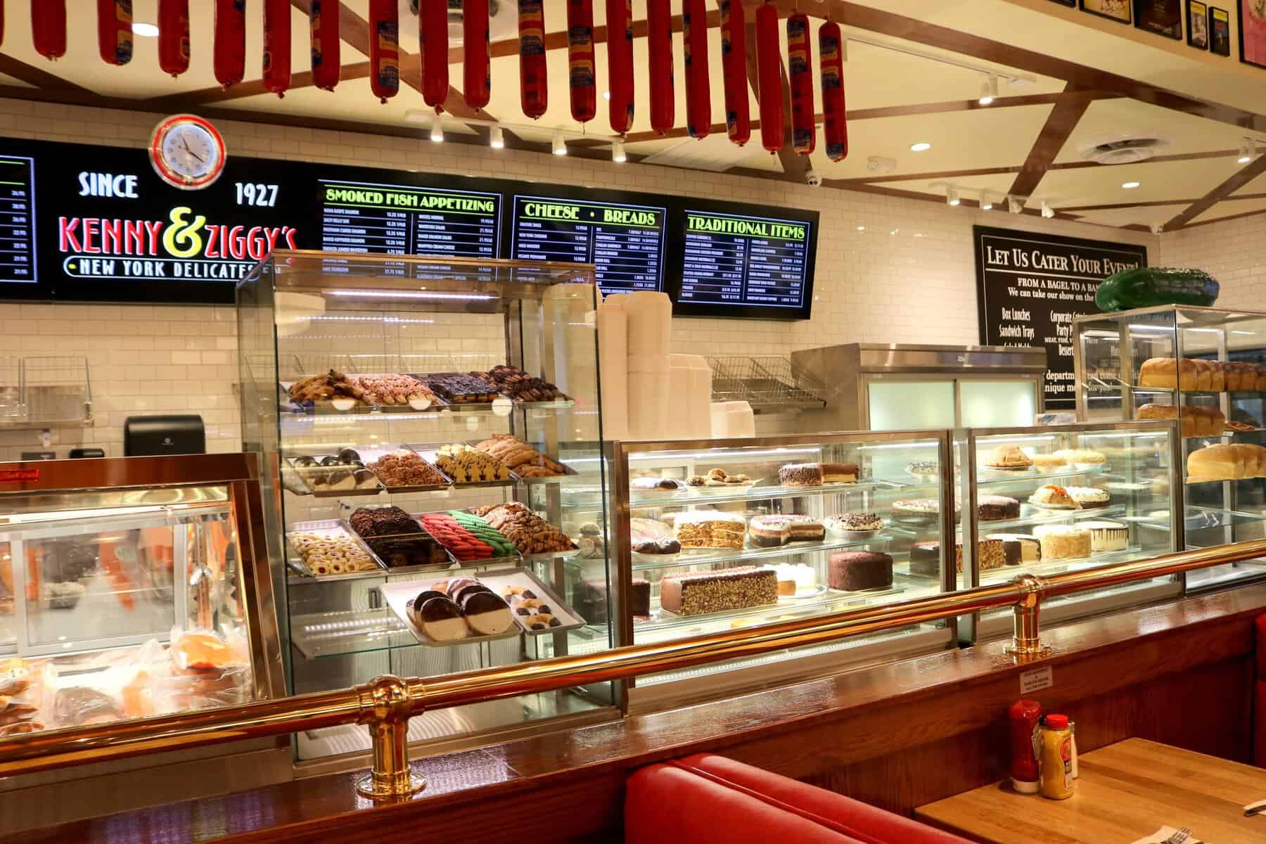 Deli counter with hanging salamis, bakery cases and the Since 1927 sign at Kenny & Ziggy's in Houston