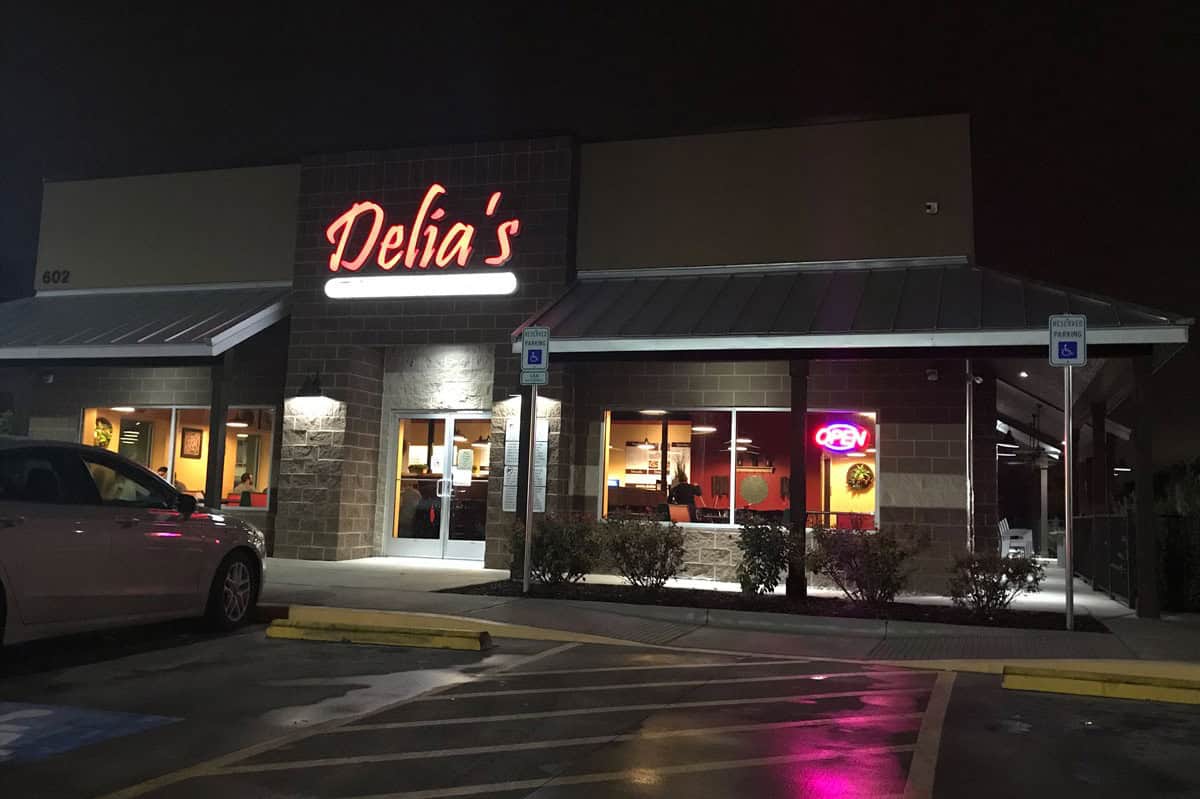 Delia's Tamales storefront lit up at night in Texas