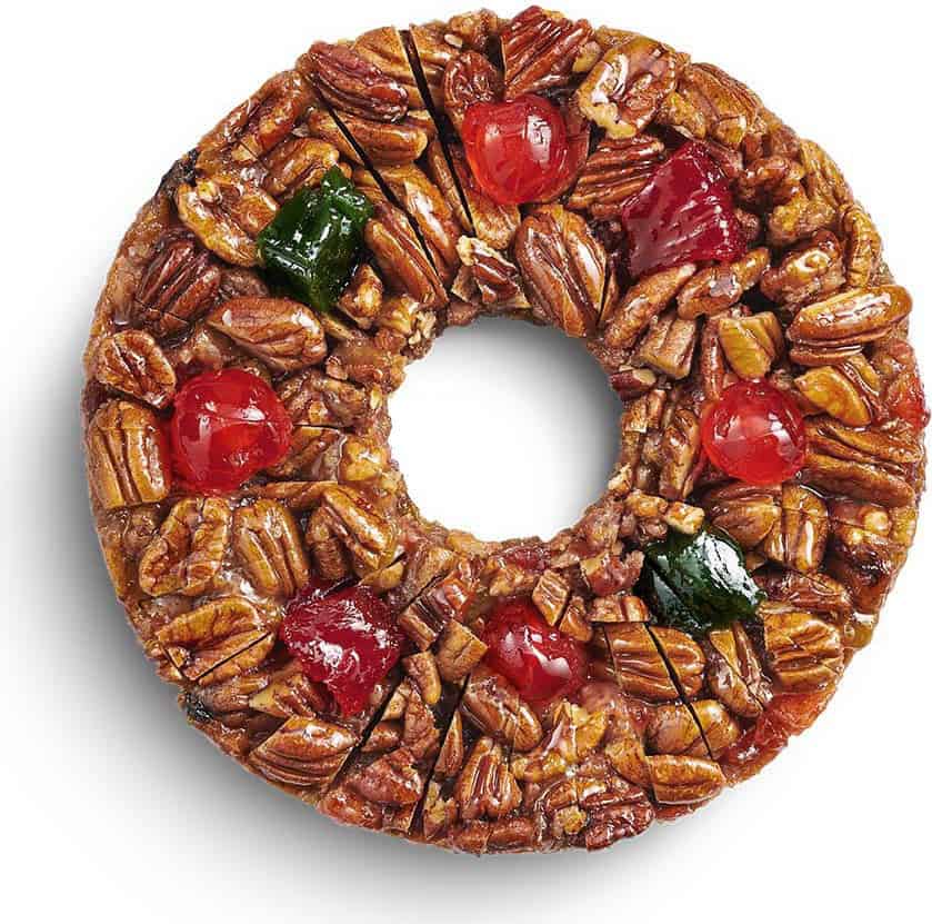 Close-up of a DeLuxe fruitcake topped with pecans and candied cherries at Collin Street Bakery