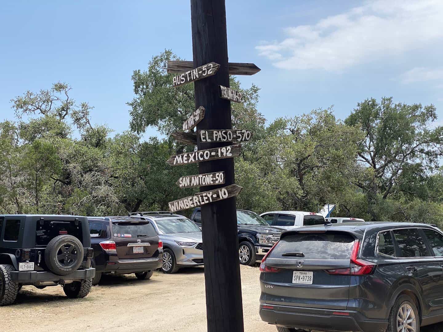 A wooden signpost pointing to Wimberley and other Texas towns outside Devil's Backbone Tavern in Fischer, Texas