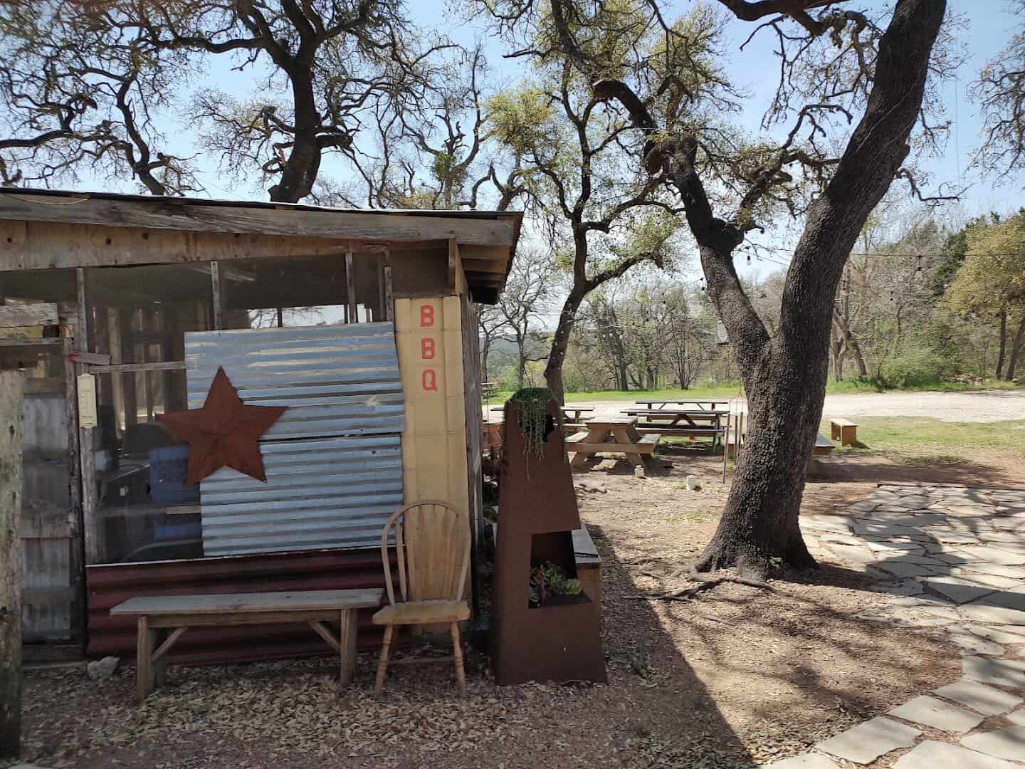 Picnic tables under live oak trees outside Devil's Backbone Tavern in Fischer, Texas