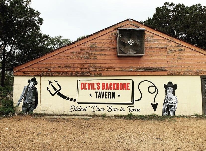 Mural reading Oldest Dive Bar in Texas on the wall at Devil's Backbone Tavern in Fischer, Texas