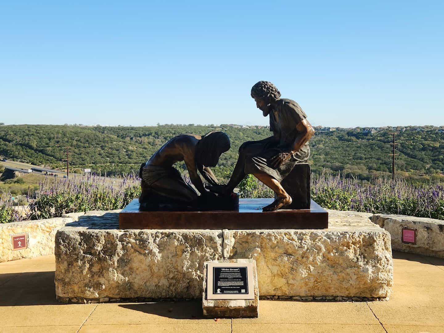 Divine Servant bronze of Jesus washing Peter's feet overlooking the Hill Country at the Coming King Sculpture Prayer Garden