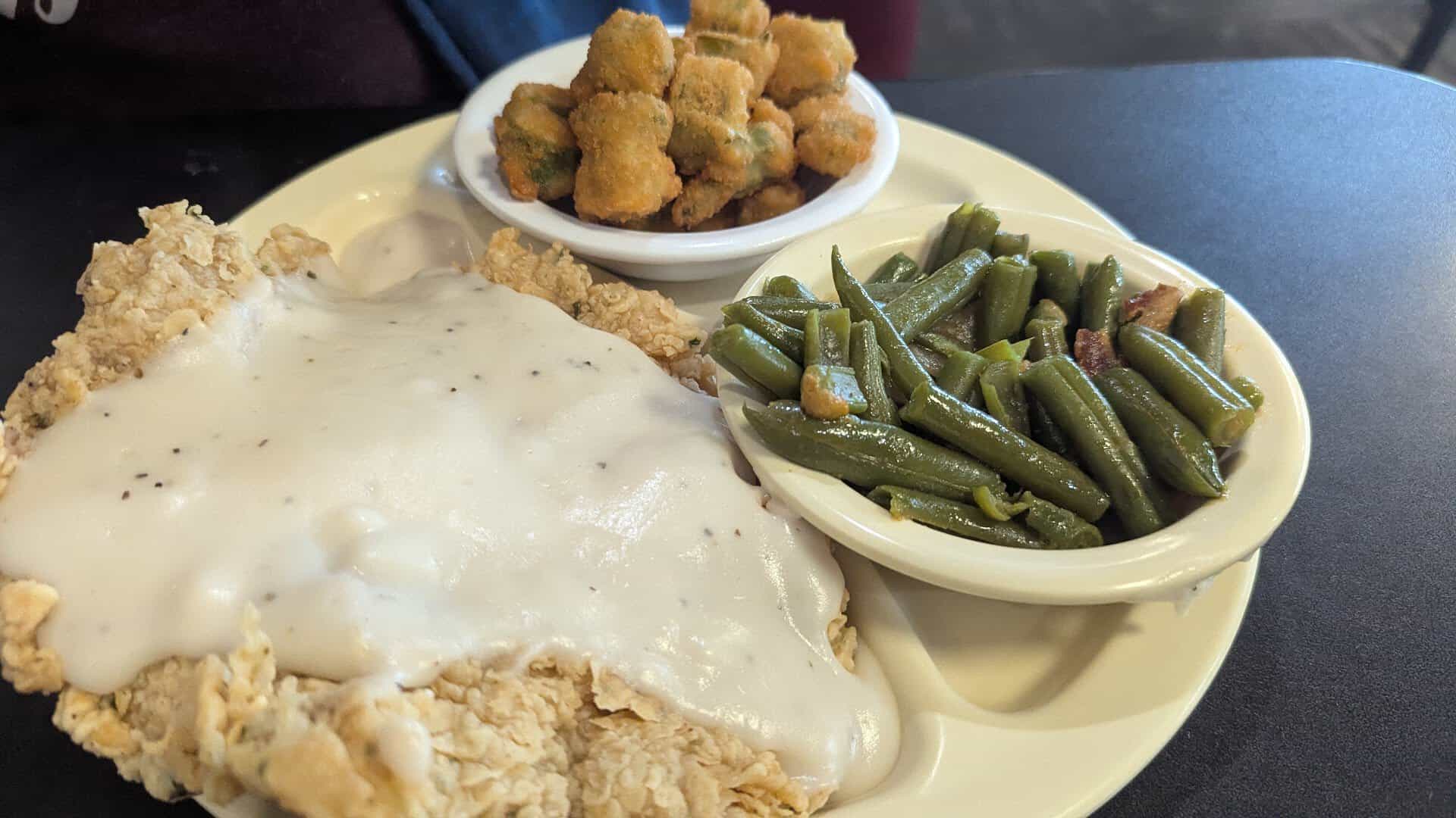 Chicken fried steak smothered in cream gravy with green beans and fried okra at Dixie House Cafe in Fort Worth, Texas
