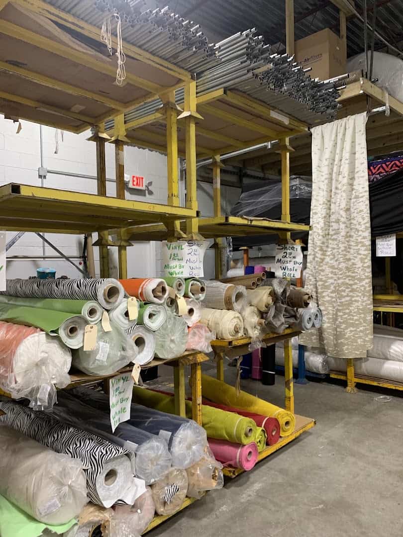 Rolls of fabric and decorative trim on racks at Wherehouse Fabrics in Dallas