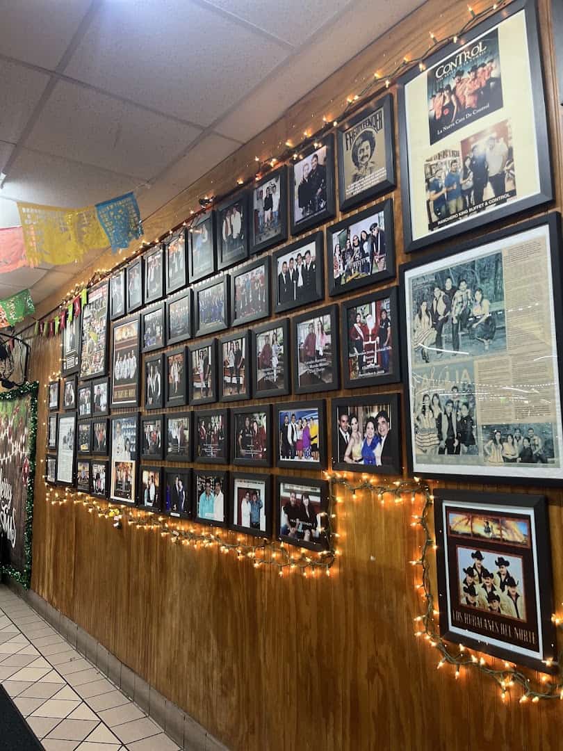Wall of framed family photos at Ranchero King Buffet in Houston