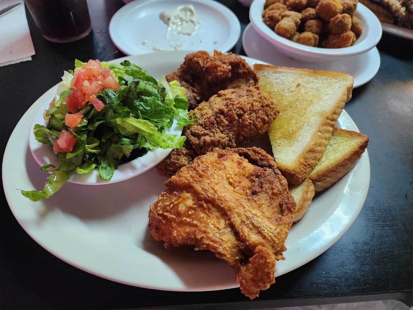 Golden fried chicken plate with salad and fried okra at Mary's Cafe in Strawn, Texas