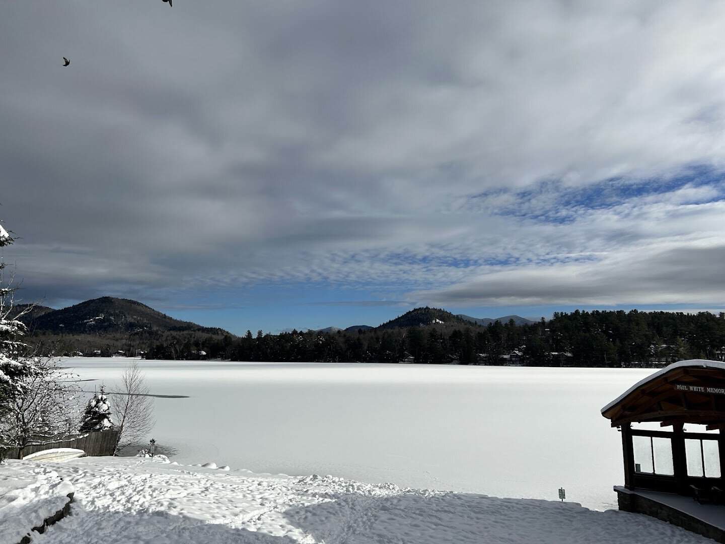 Snow-covered frozen Mirror Lake framed by Adirondack peaks, Lake Placid, New York