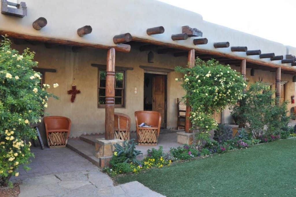 Adobe courtyard with equipale chairs and roses at Los Portales, Gage Hotel