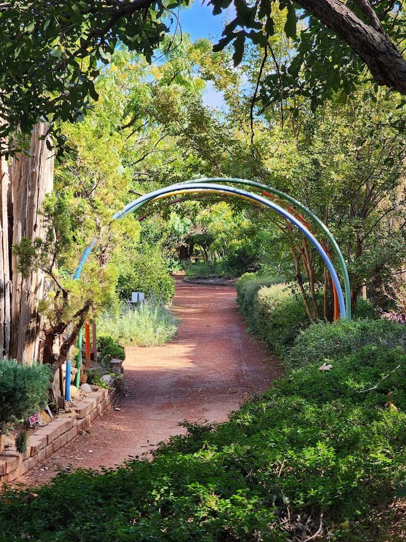 Garden path with a colorful arch and spring blooms at Clark Gardens in Weatherford, Texas