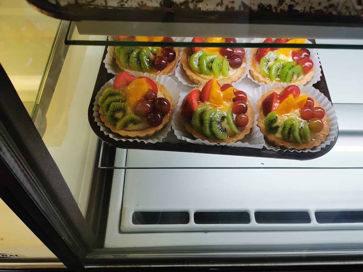 Glazed fruit tarts in the pastry case at Pfeifer's German Bakery