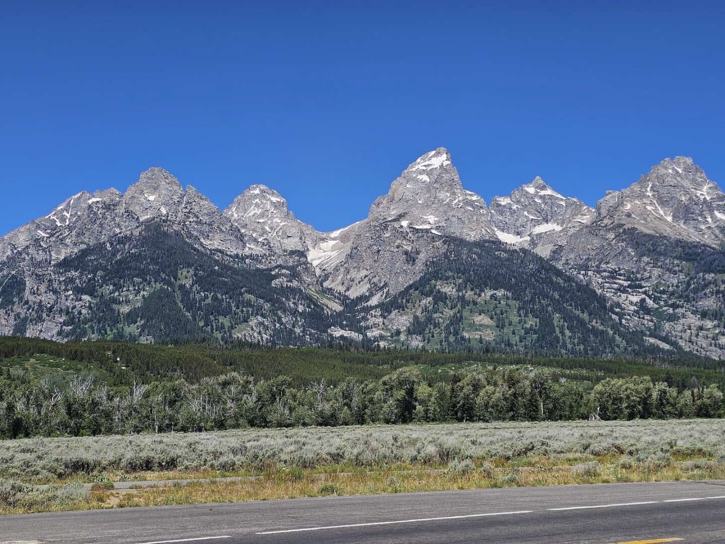 The jagged, snow-capped peaks of the Teton Range rising above the valley in Grand Teton National Park, Wyoming