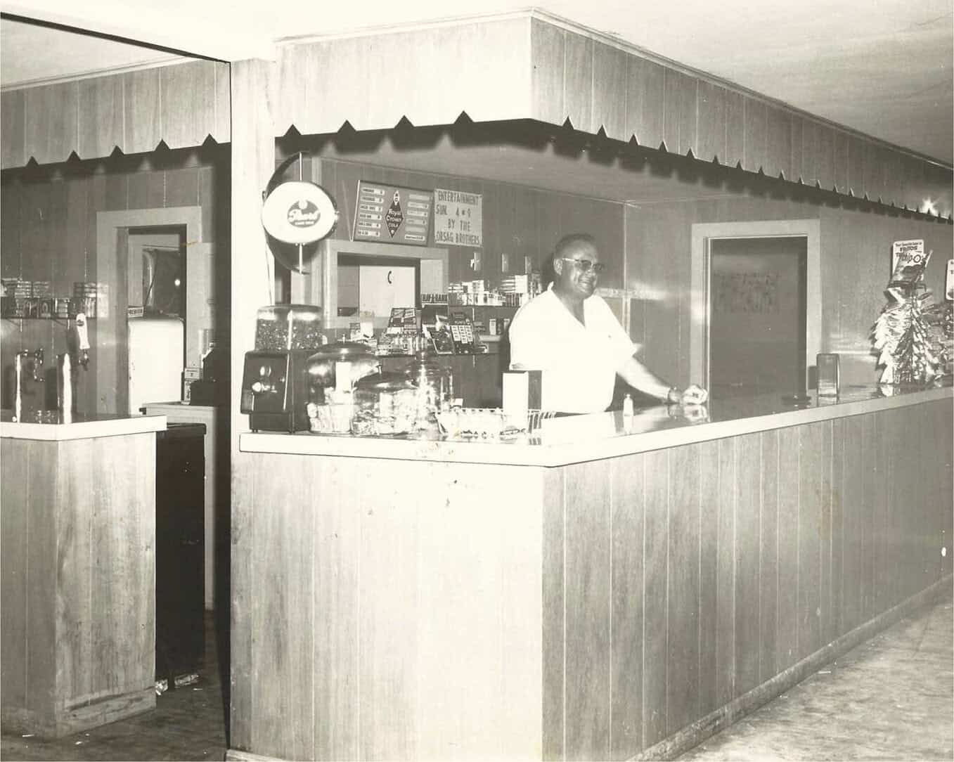 Archival photo of an owner behind the counter at Green's Sausage House