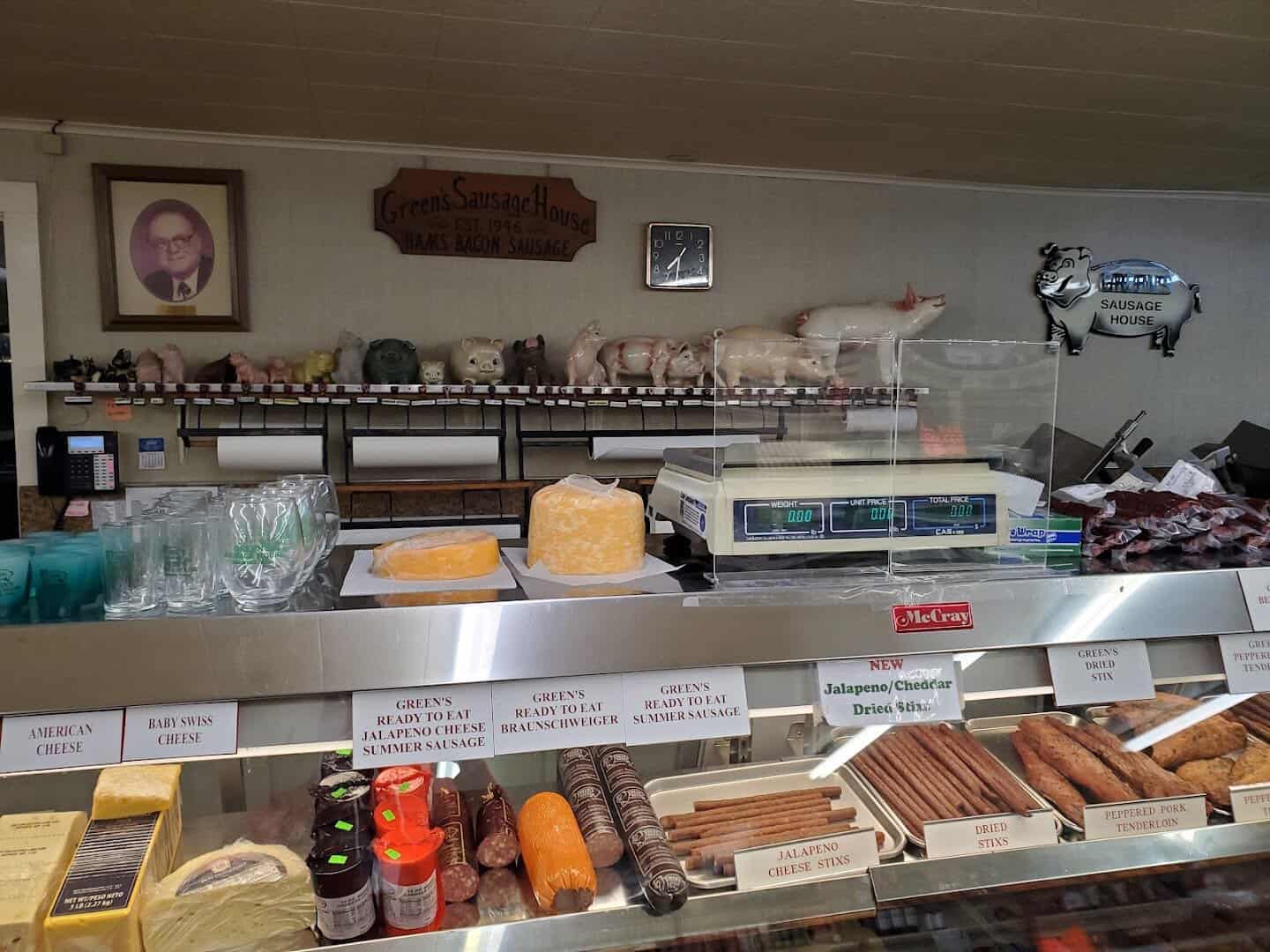 Green's Sausage House meat and cheese case with summer sausage, bacon, and blocks of cheddar