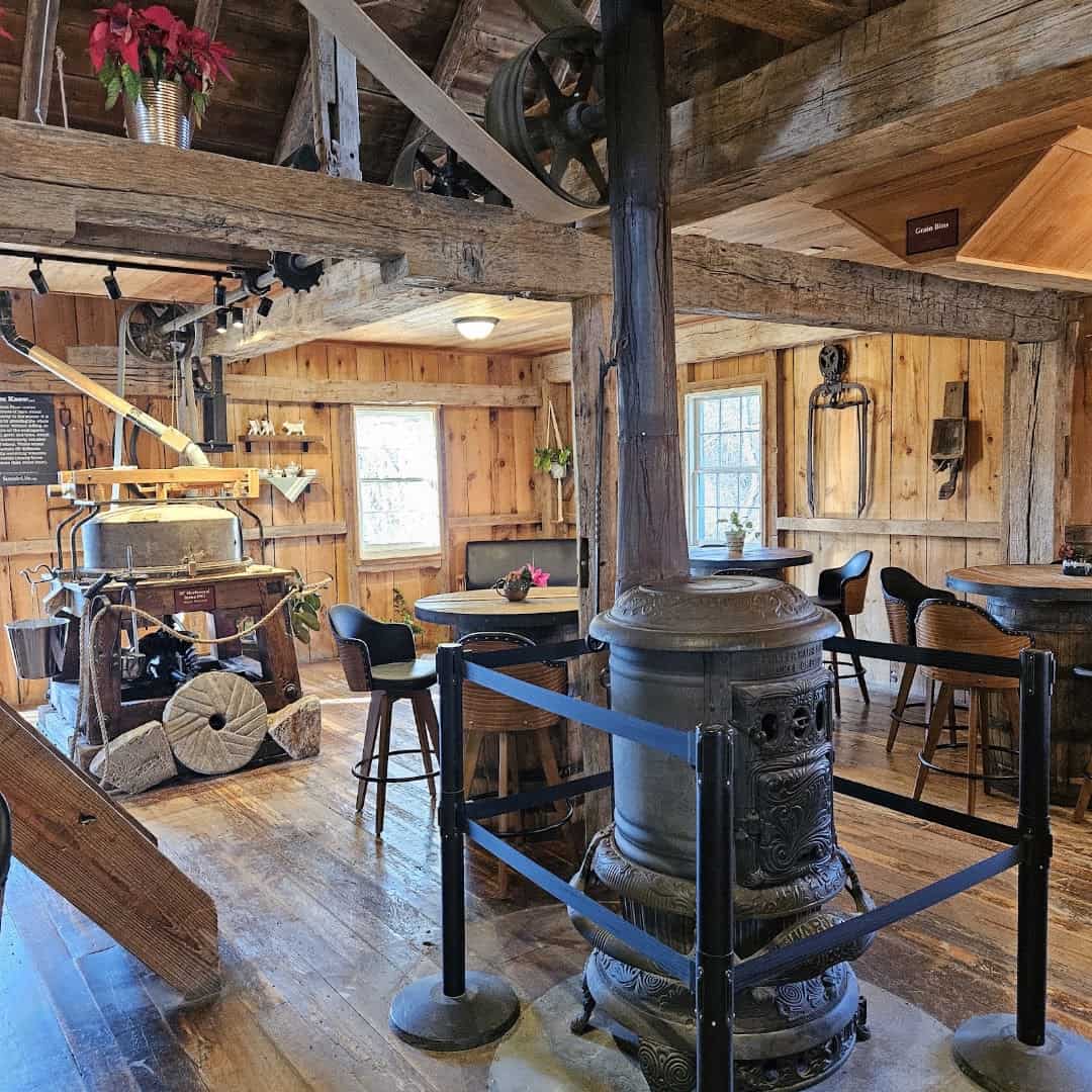 Millstones and grinding machinery inside the water-powered gristmill at Homestead Heritage near Waco, Texas