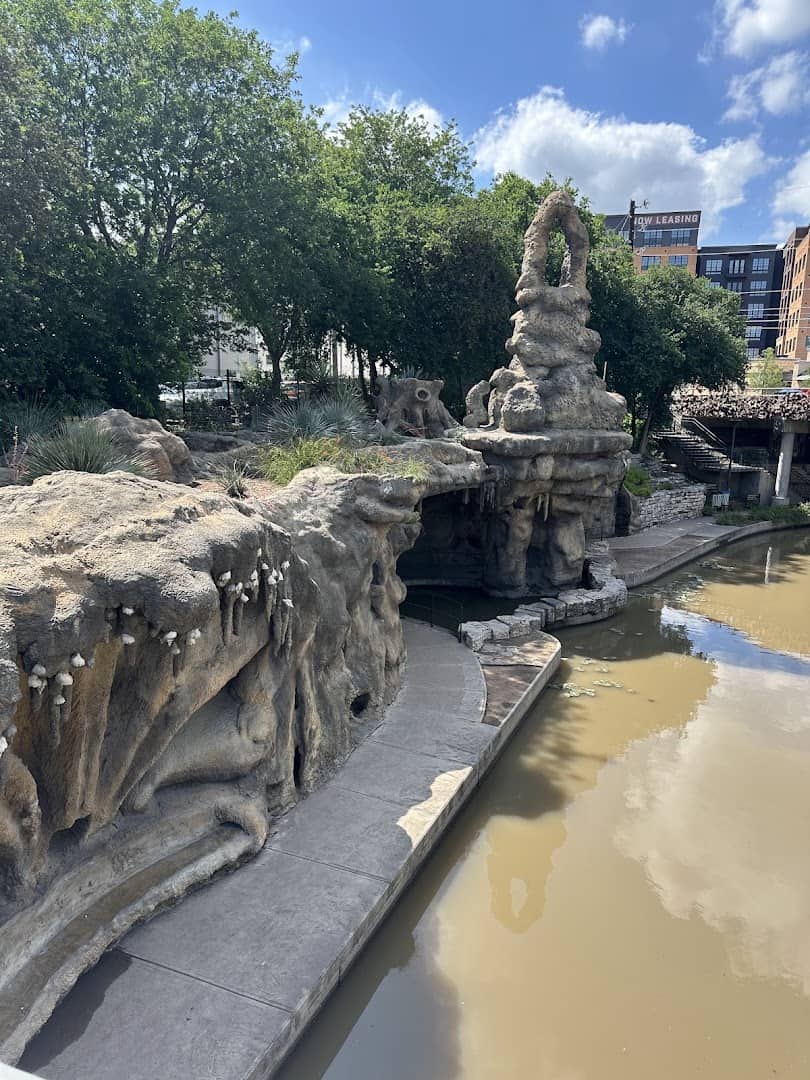 The Grotto's carved cave and spire seen from the San Antonio River Walk