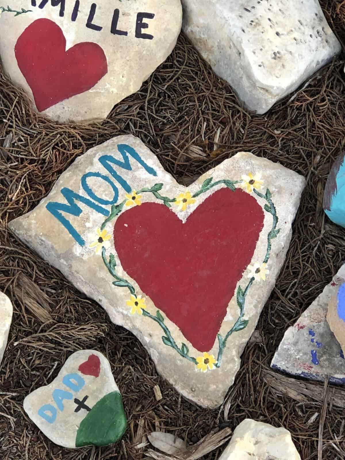 Hand painted prayer rocks with hearts at the Coming King Sculpture Prayer Garden