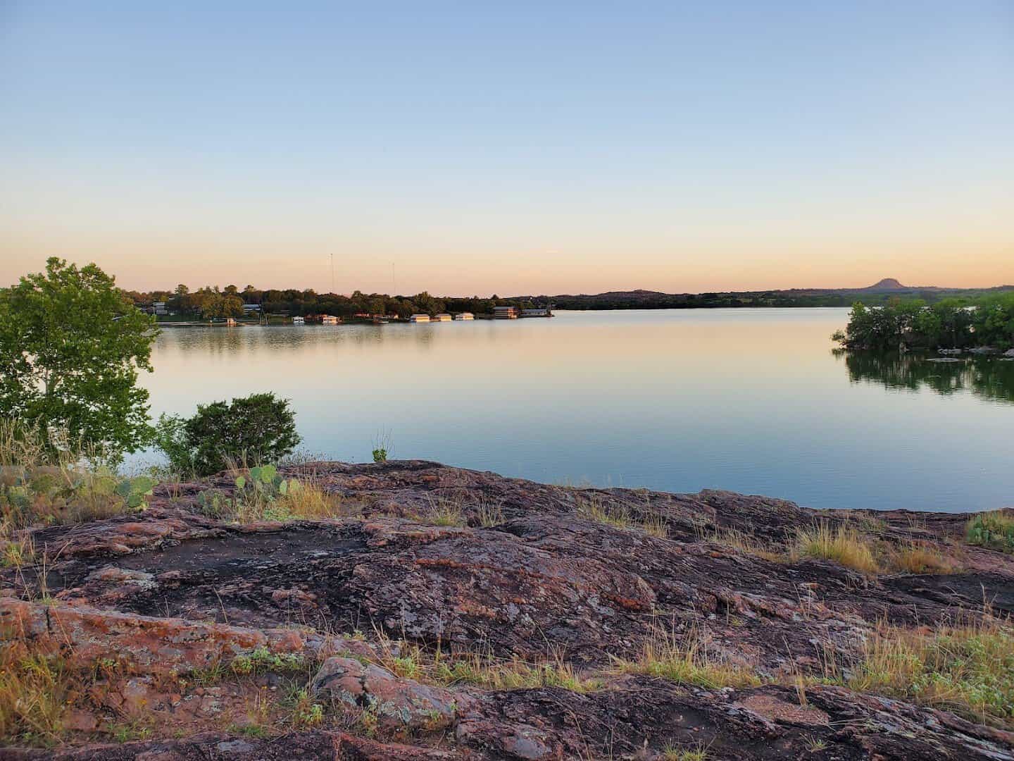 Inks Lake at golden hour with a pink granite shoreline at Inks Lake State Park, Texas