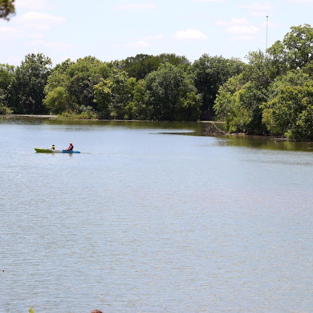 A kayaker paddling on the clear blue water of Inks Lake, Texas