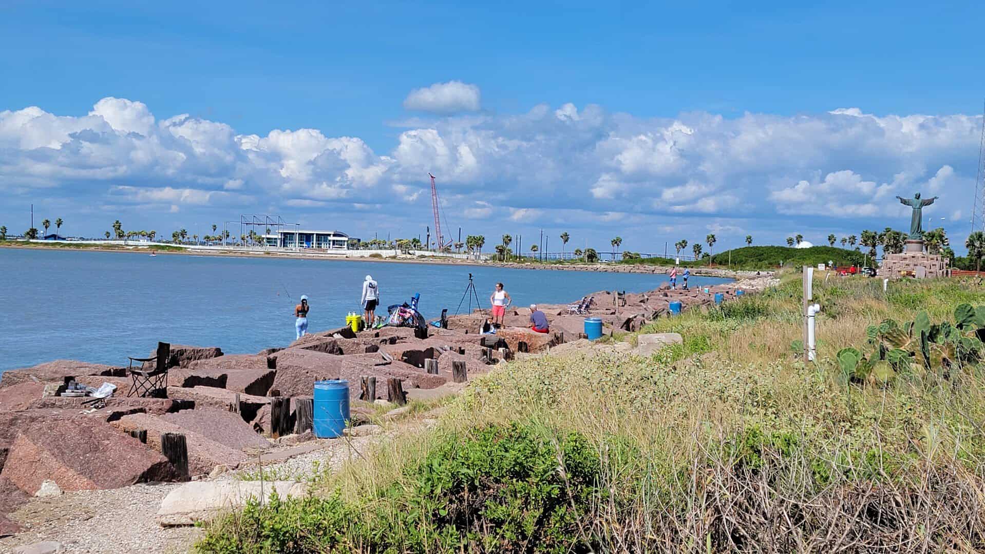 Sunny Gulf beach with palms and a jetty at Isla Blanca Park, South Padre Island, Texas