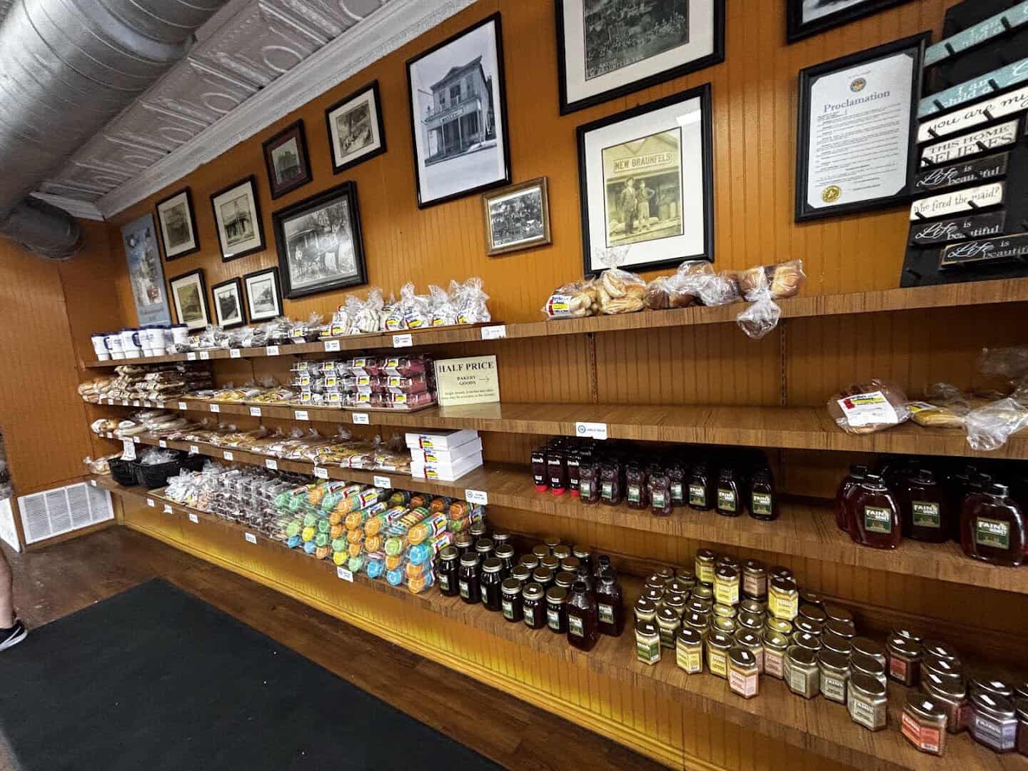 Shelf of jams and jars under historic photos at Naegelin's Bakery in New Braunfels