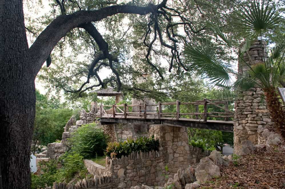 A stone bridge shaded by trees at the Japanese Tea Garden in San Antonio