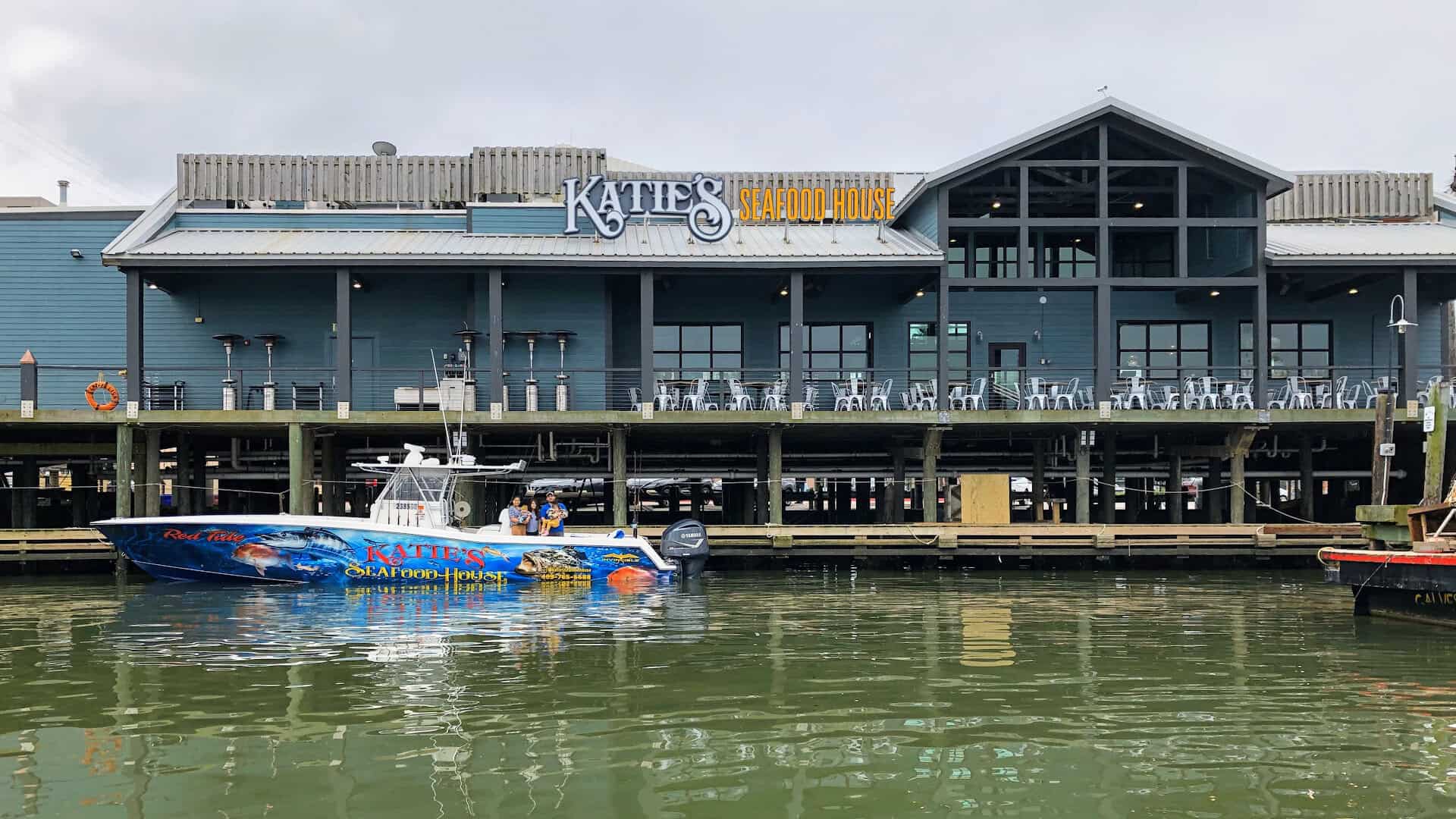 Katie's Seafood House on Pier 19 with its branded fishing boat in Galveston Harbor