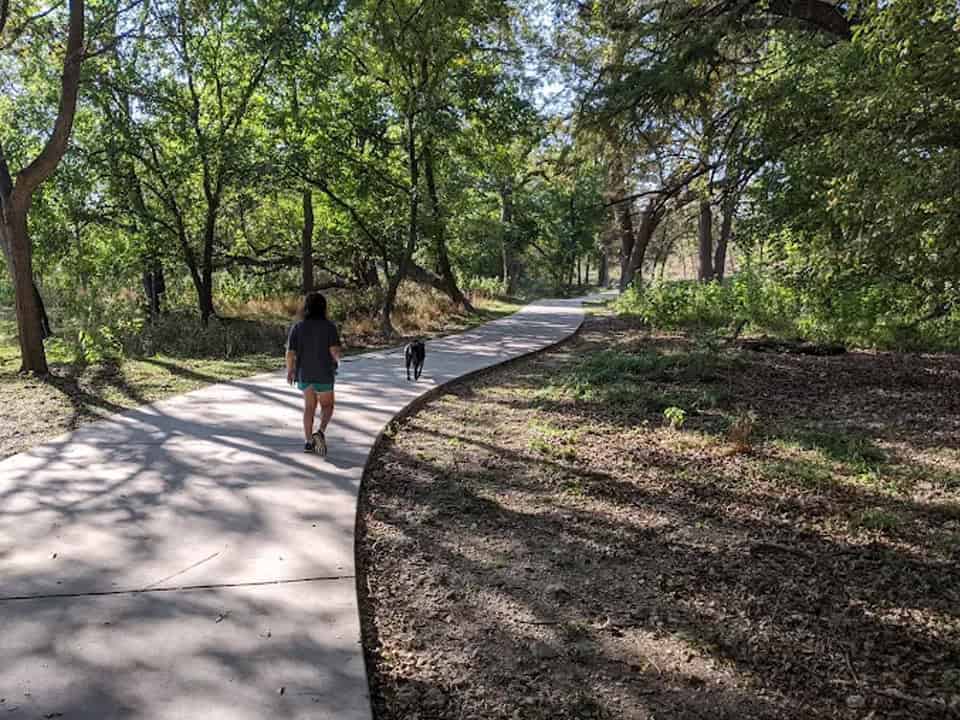Paved river trail winding through shady trees along the Guadalupe in Kerrville