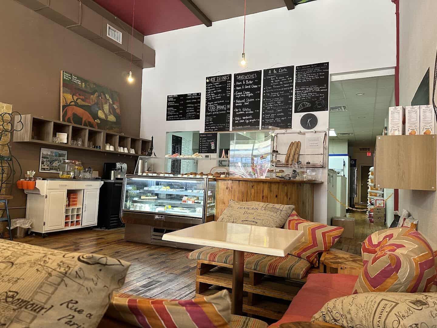 Interior of La Boulangerie in San Antonio with French menu boards, pastry case and cozy seating