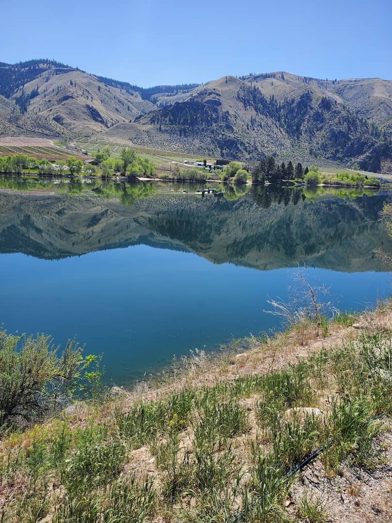 The blue water of Lake Chelan mirroring dry hills under a clear sky, Chelan, Washington