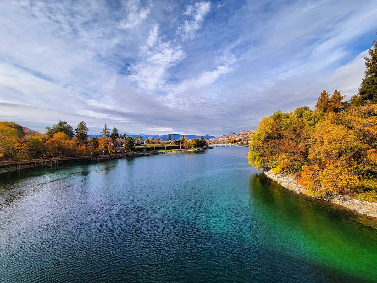 Golden fall trees along the teal water of Lake Chelan, Chelan, Washington