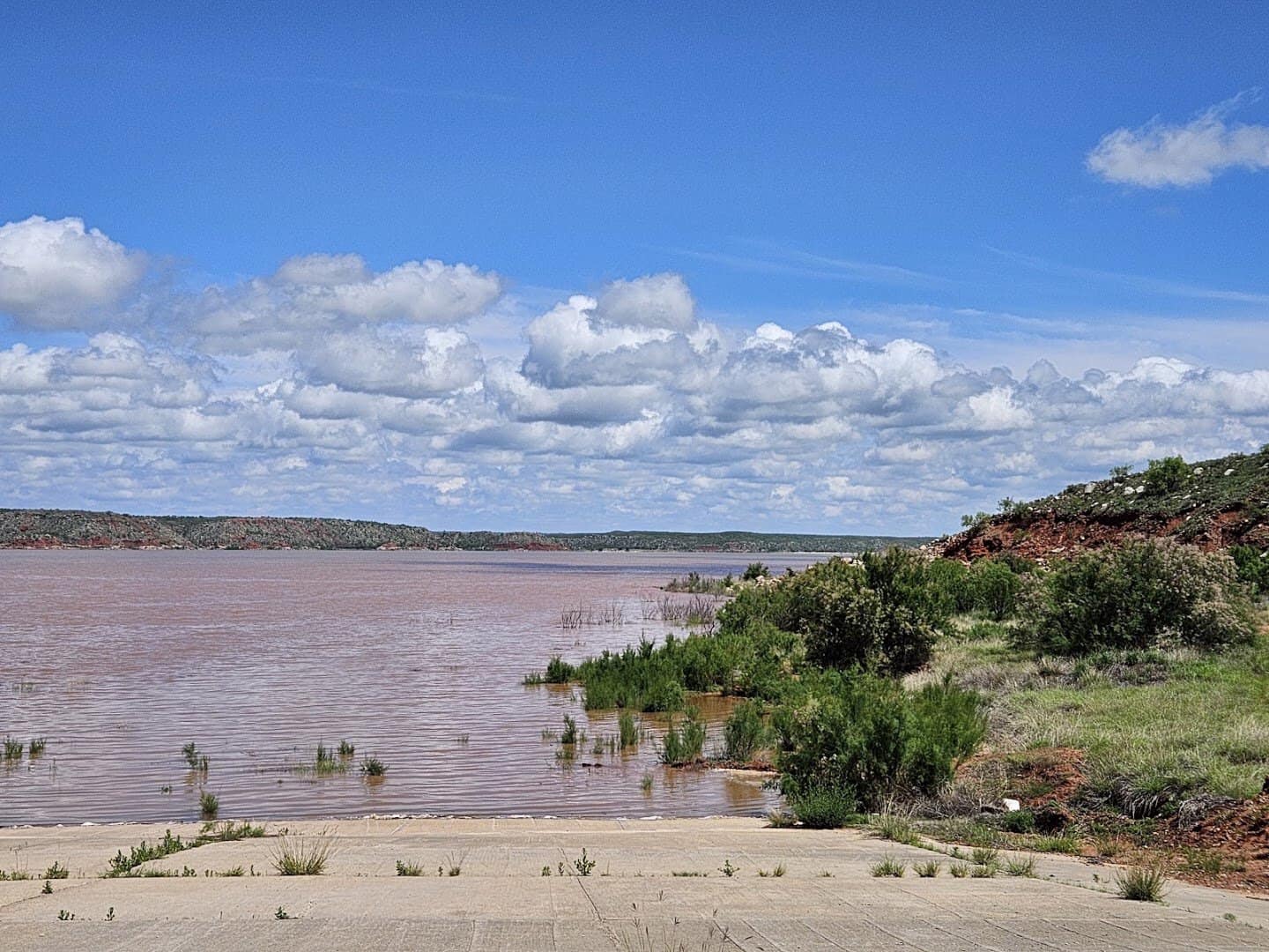 Red tinted water and canyon banks at Lake Meredith