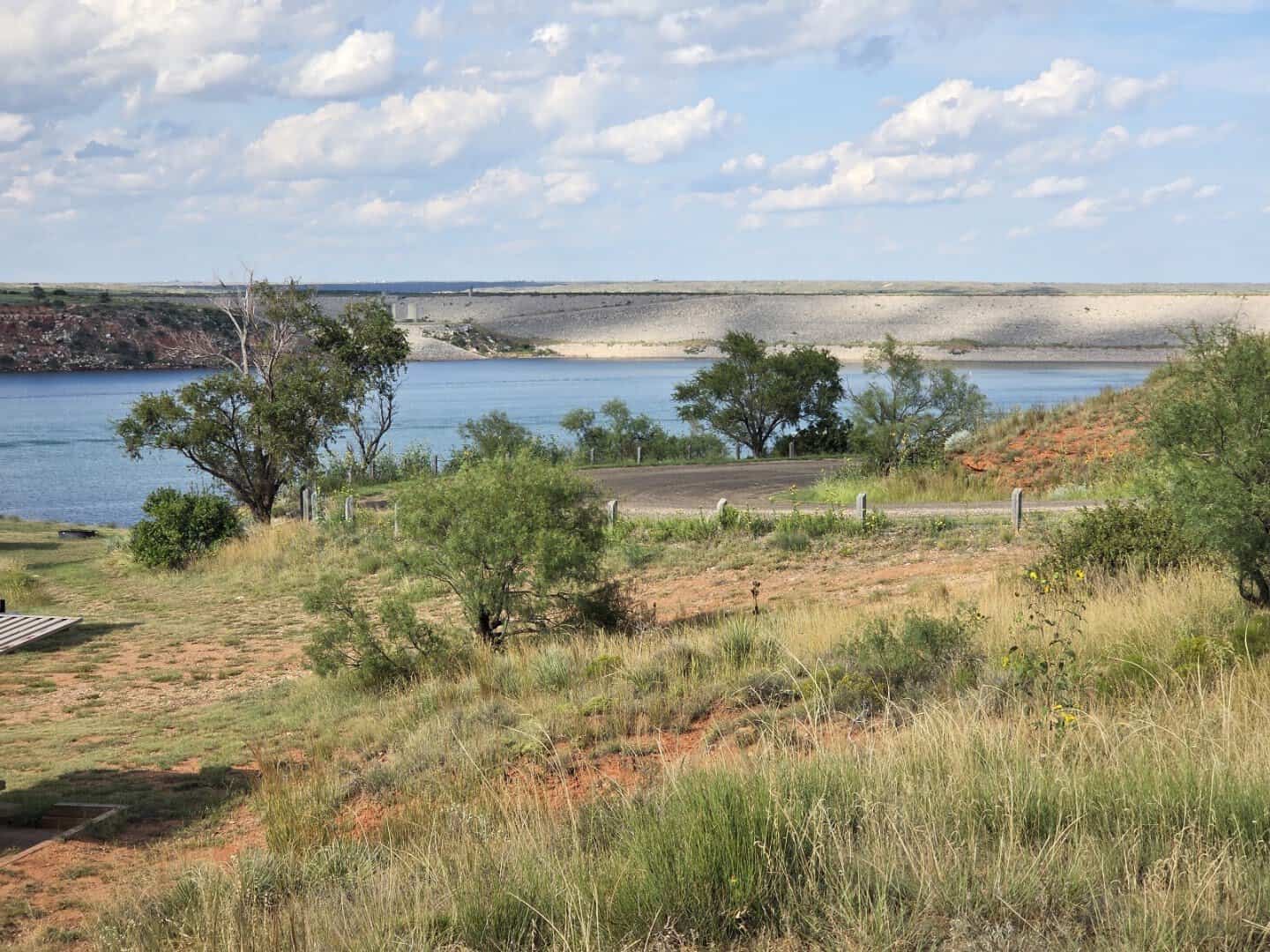 Lake Meredith shoreline with grassy banks under the clouds