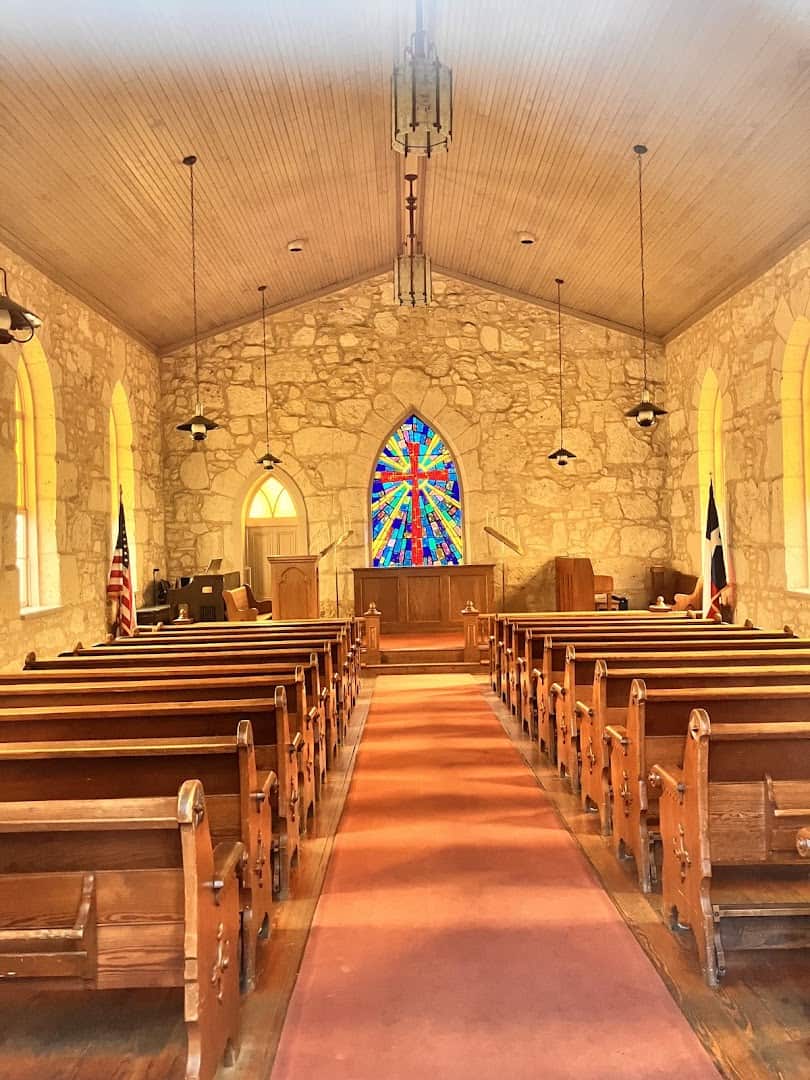 Stone interior and stained-glass window of the Little Church of La Villita in San Antonio