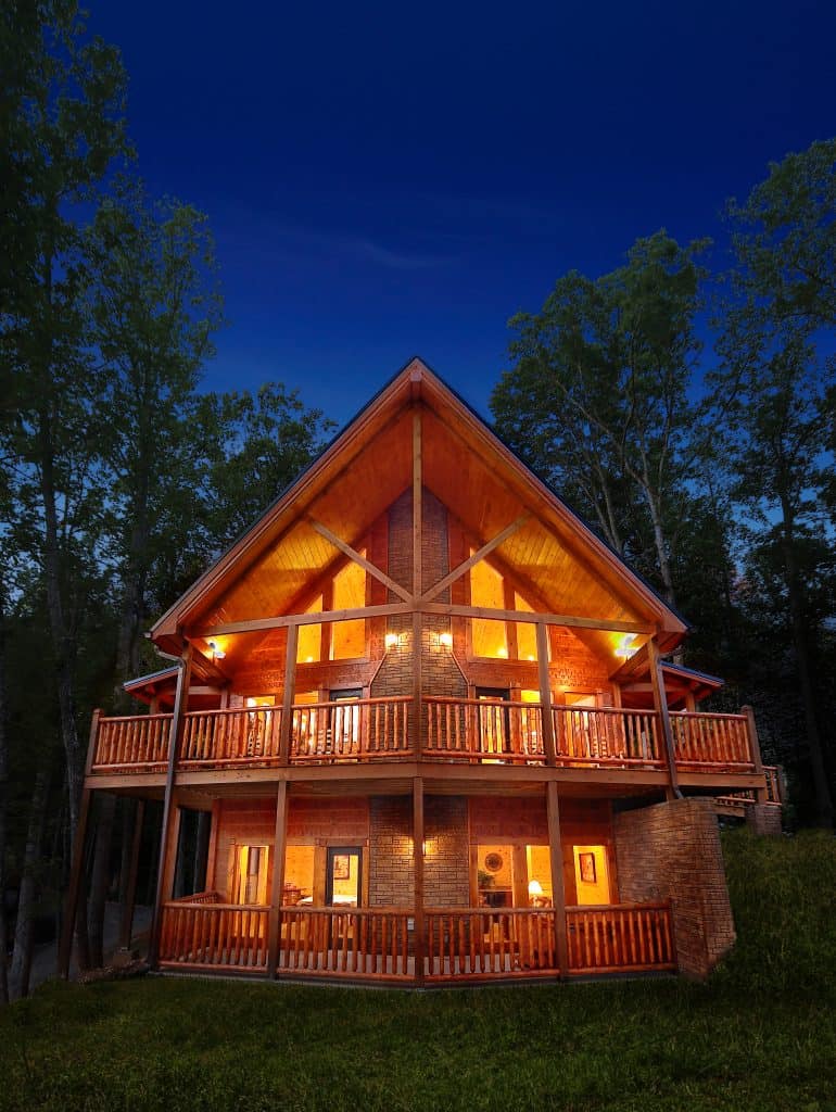 A log cabin lit up at twilight in the Smoky Mountains at Elk Springs Resort, Gatlinburg, Tennessee