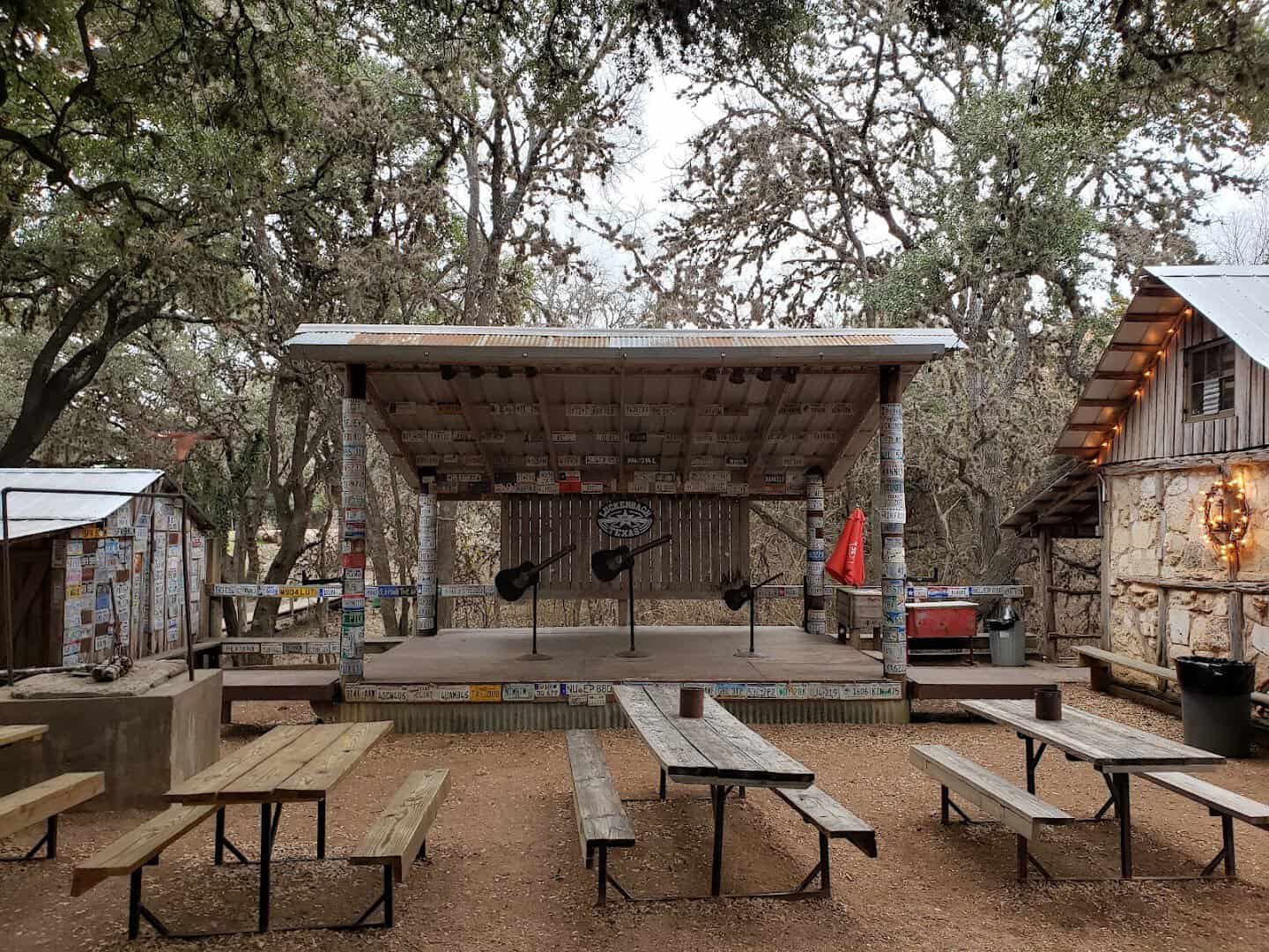 Outdoor stage and picnic tables under the oaks at Luckenbach Texas