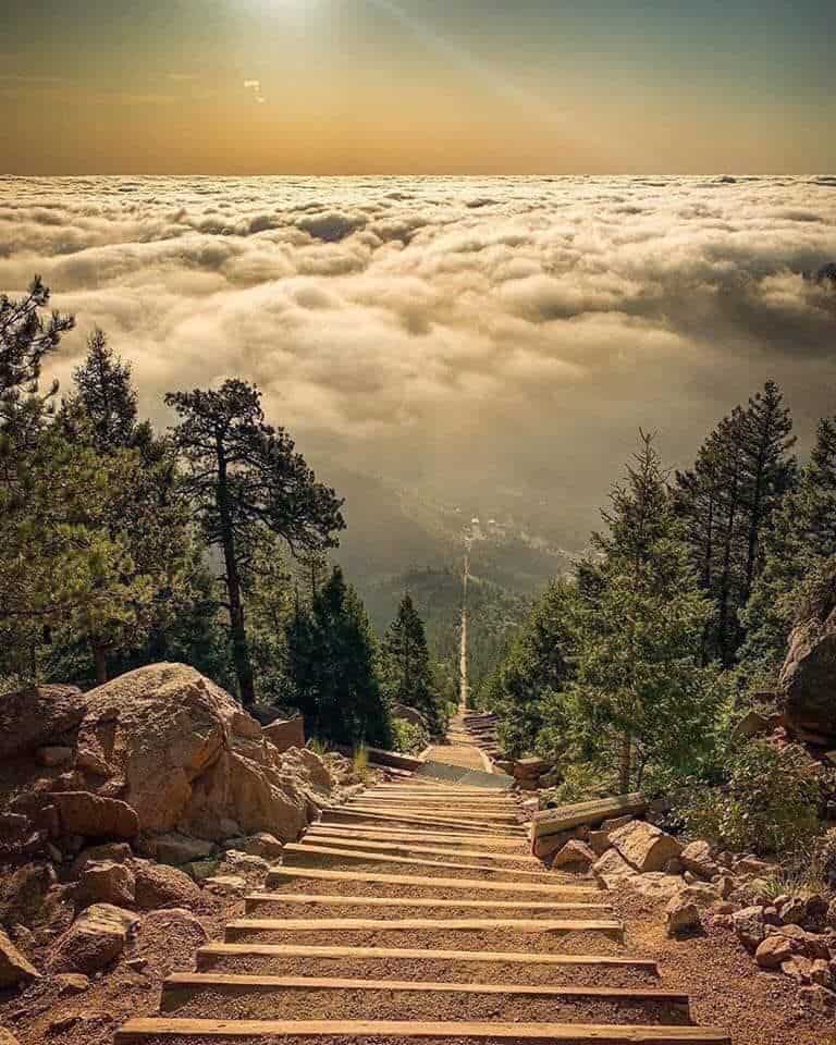 The steep railroad-tie staircase of the Manitou Incline climbing above the clouds near Manitou Springs, Colorado