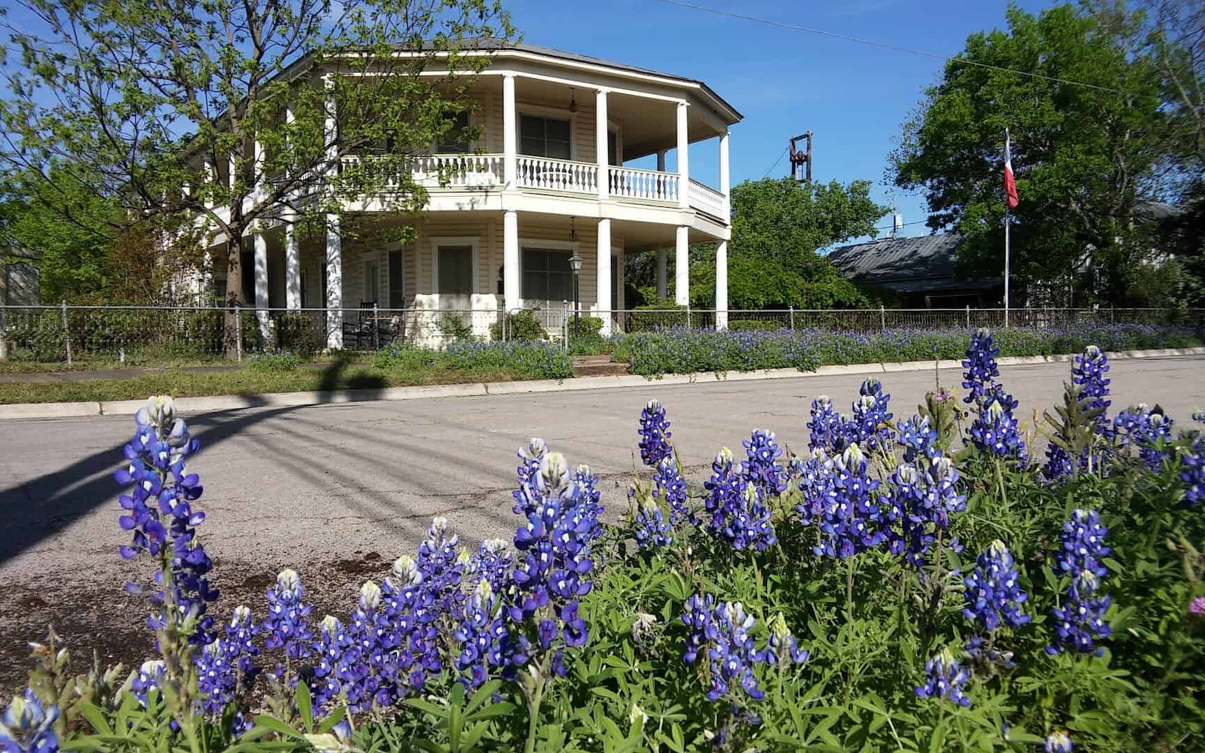 Historic stone building with bluebonnets in Marble Falls, Texas
