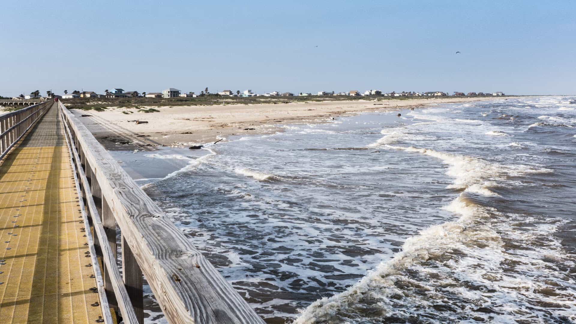 Long fishing pier reaching over the Gulf surf at Matagorda Beach, Texas