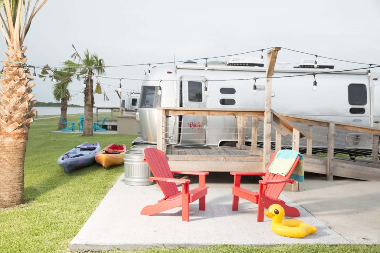 Vintage Airstream trailer and red chairs with kayaks at Matagorda Bay Nature Park, Texas