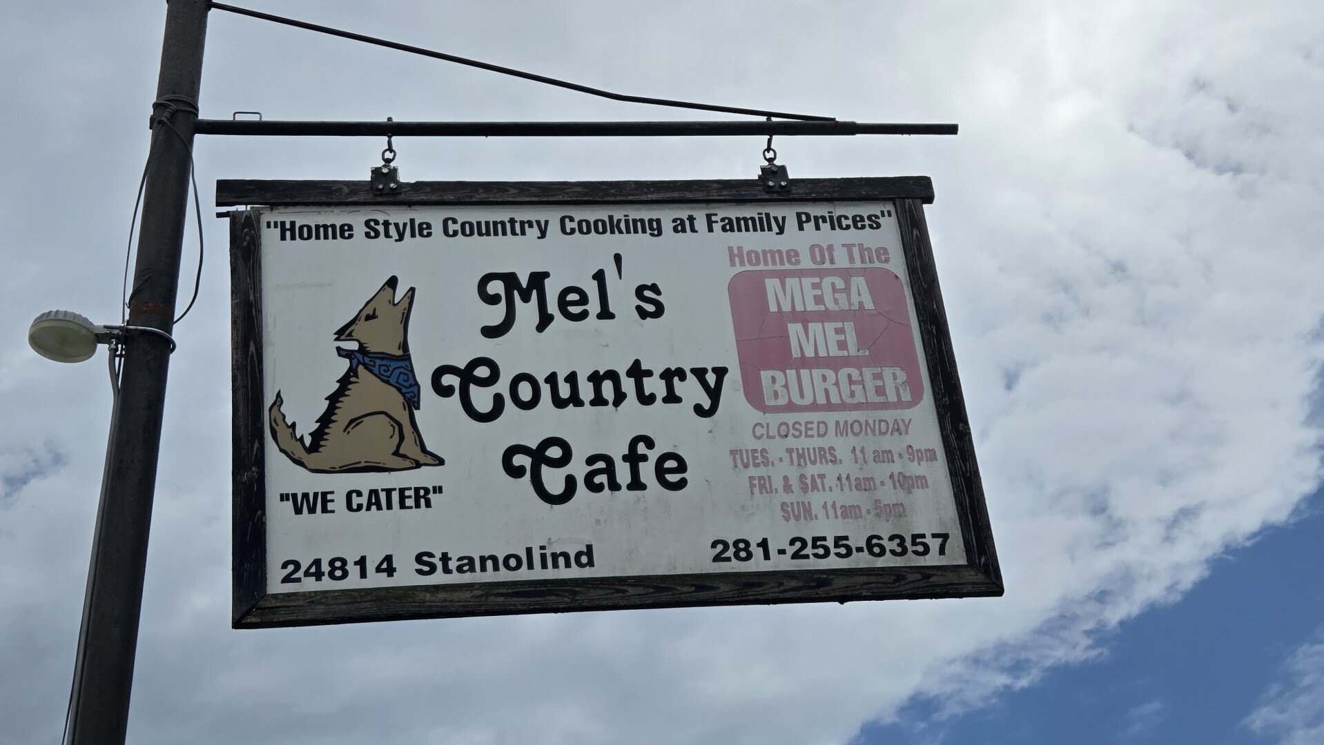 Mels Country Cafe hanging sign with address on Stanolind Road in Tomball, Texas