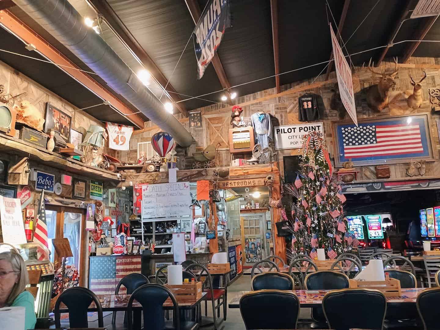 The memorabilia-packed dining room with flags and a Pilot Point city limit sign at Bebo's and Kathy's Cafe